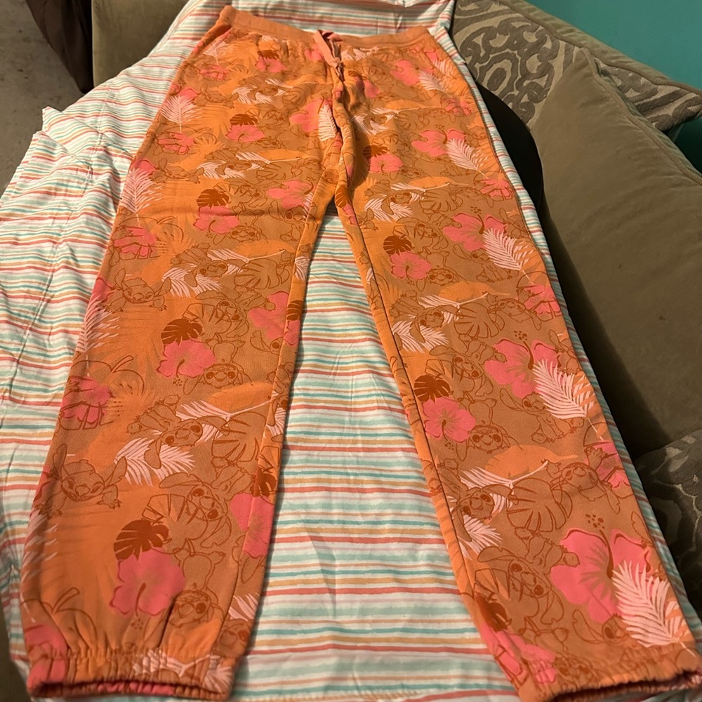 NWOT Disney M joggers in orange jungle pattern with character Stitch.